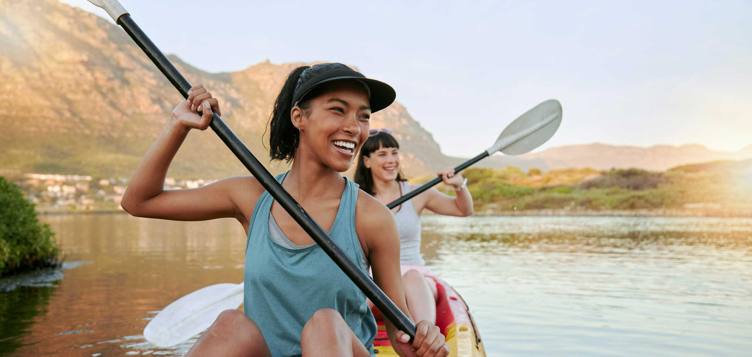 two women kayaking together and laughing