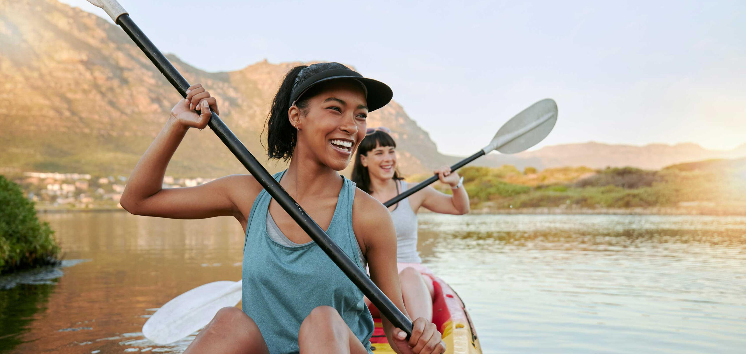 Make time to have fun with friends two women kayaking together and laughing