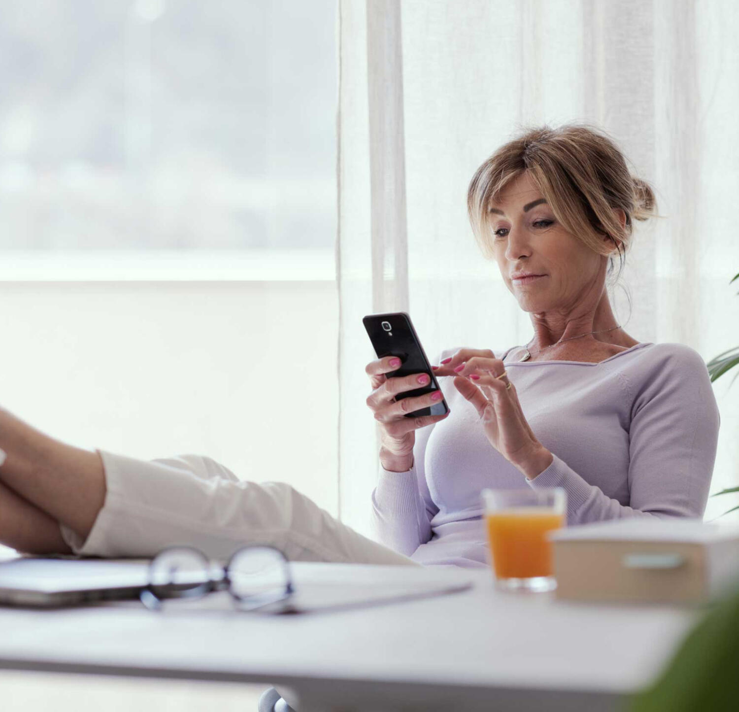 a woman prioritizing her many tasks on her phone