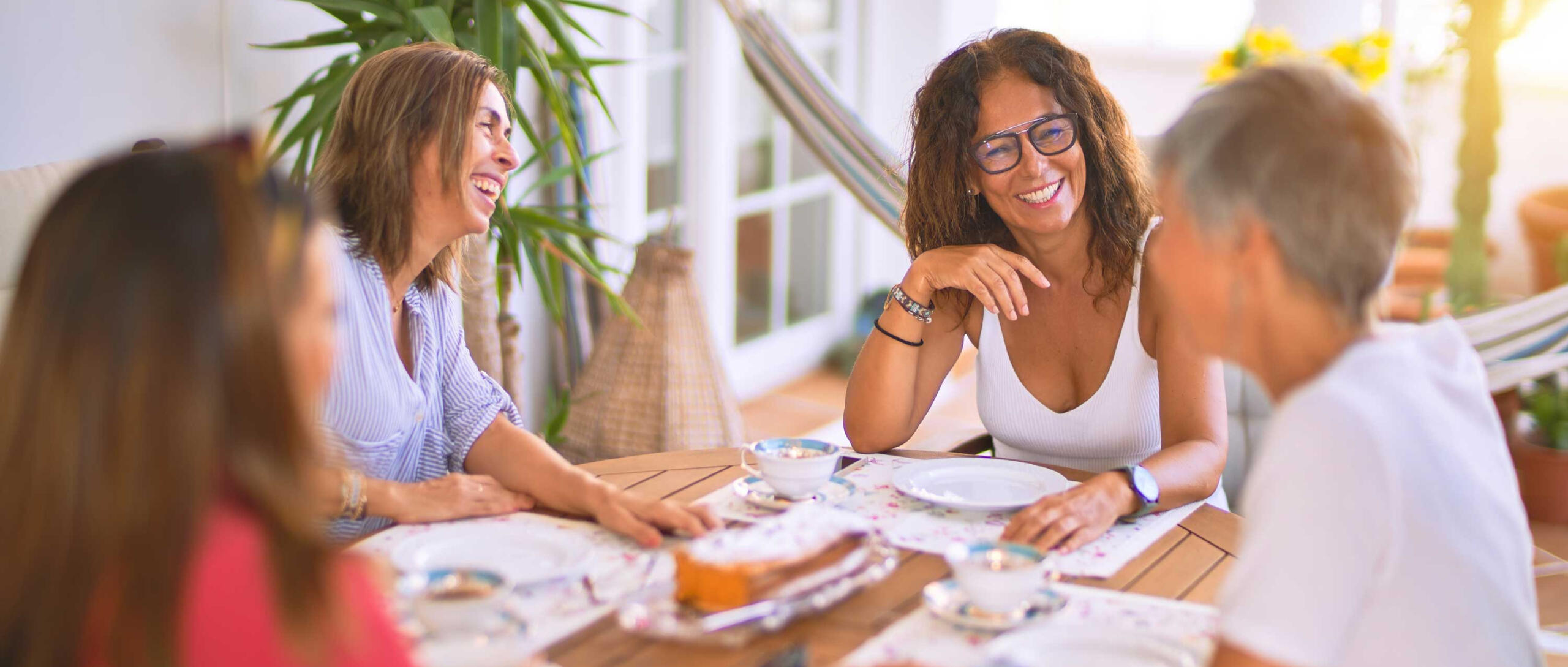 four women having breakfast together and laughing